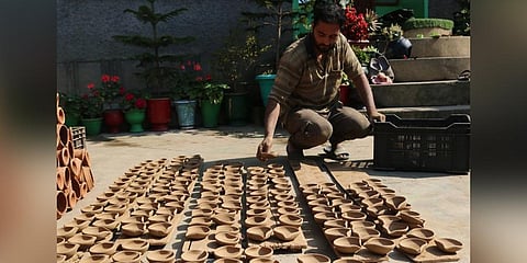 Potter Mohammed Umar arranges the diyas | Express