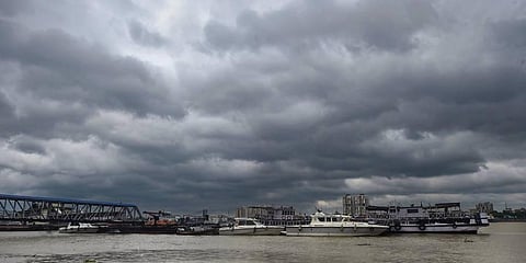Dark clouds hover in the skies above the boats parked on the bank of Ganga river, as a precautionary measure ahead of the landfall of cyclone Sitrang. (Photo | PTI)