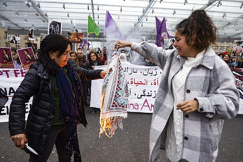 Iranian women burn their headscarves during a rally against the death of Iranian Mahsa Amini in Bern, Switzerland, Sept. 27, 2022. (Photo |AP)