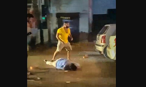 In this screenshot taken from a social media viral video, a man bludgeons another with a brick over a parking dispute on Tuesday evening, in Ghaziabad. (PTI)