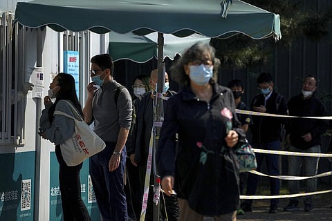 Residents line up to get their routine COVID-19 throat swabs at a coronavirus testing site in Beijing. (File Photo | AP)