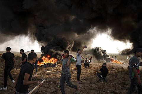 Palestinians burn tires during a protest against Israeli military raid in the West Bank, along the border fence with Israel, in east of Gaza City on Oct. 25, 2022. (File Photo| AP)