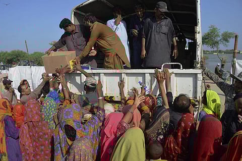 Displaced families, who fled their flood-hit homes, jostle to get relief aid distributed by soldiers of Pakistan rangers, in Dera Allahyar, in Jaffarabad, Saturday, Sept. 17, 2022. (Photo | AP)