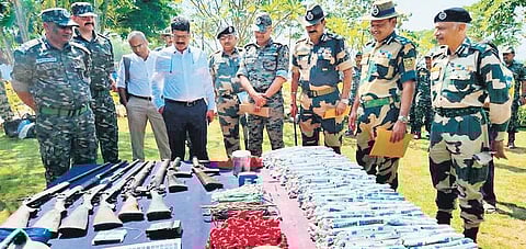 Senior police and BSF officers look at explosives and arms seized from Maoist dump