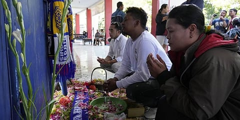People gather to pray for the victims of Saturday's soccer match stampede in front of gate 13 at the Kanjuruhan Stadium in Malang, Indonesia. (Photo | AP)