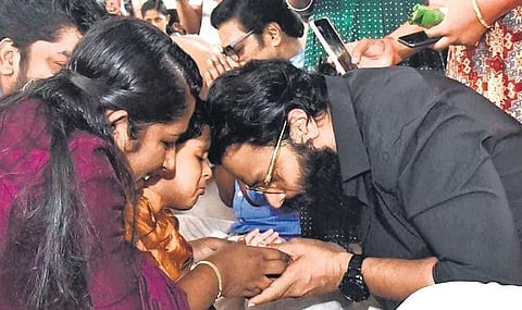 Actor Jayasurya administering first letters to a child at Pavakkulam temple