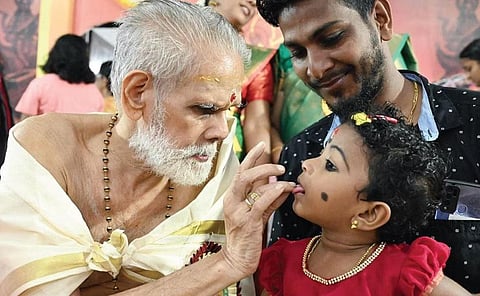 A priest initiating a child into the world of letters at Thunchan Smaraka Samithi at Iranimuttam in Thiruvananthapuram on Wednesday |B P Deepu