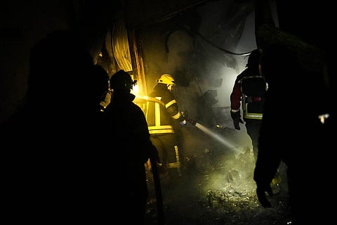 Ukrainian firefighters work among debris following a Russian shelling in Kharkiv, Ukraine, early Saturday. (Photo | AP)