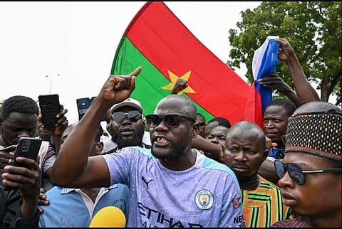 Supporters of Burkina Faso's new junta leader Ibrahim Traore hold a national flag during a demonstration. (Photo | AFP)