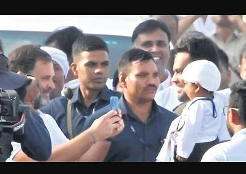 Congress leader Rahul Gandhi clicks pictures of a girl with her father during the Bharat Jodo Yatra in Mandya district on Friday | Udayashankar S