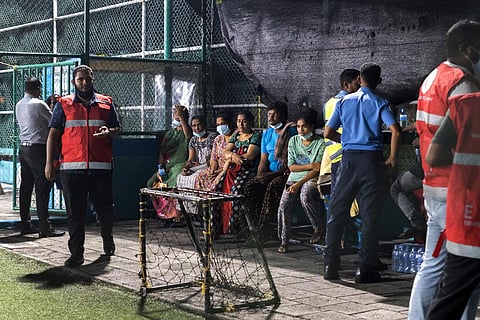 People evacuated from a fire-gutted building in Male on November 10, 2022, await relocation after a major fire swept through cramped living quarters of foreign workers. (Photo | AFP)