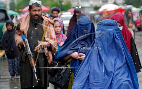Women walk through the old market as a Taliban fighter stands guard, in the city of Kabul, Afghanistan, Tuesday, May 3, 2022.(Photo | AP)