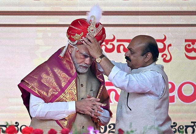 Prime Minister Narendra Modi being presented a 'peta' by Karnataka CM Basavaraj Bommai during a public meeting after the inauguration of Terminal 2 of Kempegowda International Airport and unveiling of 108 feet-tall bronze statue of Nadaprabhau Kempegowda, called 'Statue of Prosperity', in Bengaluru, on November 11, 2022.  (Photo | Shashidhar Byrappa, EPS)