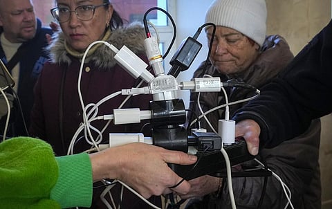 People charge their phones, try to connect to the internet and make phone calls, in central square in Kherson, Ukraine, Tuesday, Nov. 15, 2022. (Photo | AP)