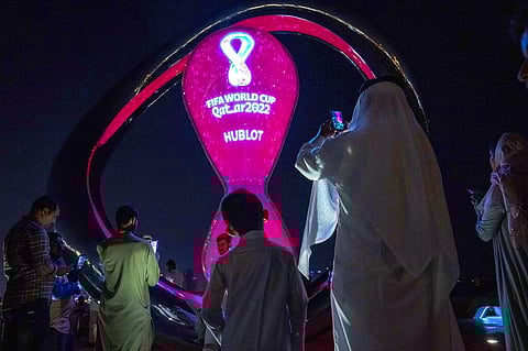 People take photos with the official FIFA World Cup Countdown Clock on Doha's corniche, in Qatar, Friday, Oct. 14, 2022. (Photo | AP)