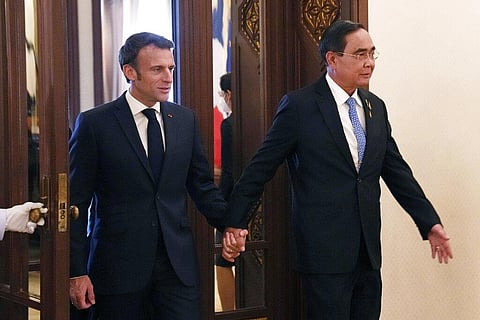 Thailand's PM Prayuth Chan-ocha walks hand in hand with French President Emmanuel Macron before their meeting at the Government House, Thursday, Nov. 17, 2022, in Bangkok, Thailand. (Photo | AP)