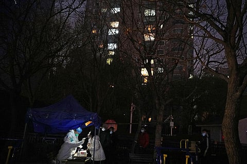 A resident gets swabbed for the COVID test outside a neighborhood in Beijing (Photo |AP)