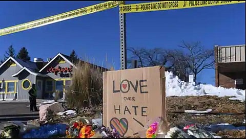 Bouquets of flowers and a sign reading 'Love Over Hate' are left near Club Q, an LGBTQ nightclub in Colorado Springs, Colorado. (Photo | AFP)