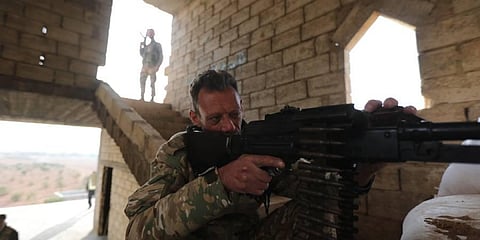 A Turkey-backed Syrian fighter sits behind a machine gun at a fortified position in Jarablus close to the border with Turkey. (Photo | AFP)