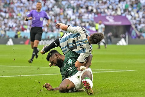 Saudi Arabia's Firas Al-Buraikan and Argentina's Nicolas Tagliafico challenge for the ball during the World Cup between Argentina and Saudi Arabia at the Lusail Stadium in Lusail, Qatar. (Photo | AP)