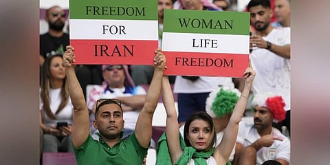 Iranian soccer fans hold up signs reading Woman Life Freedom and Freedom For Iran, prior to the World Cup group B soccer match between England and Iran in Doha, Qatar. (Photo | AP)