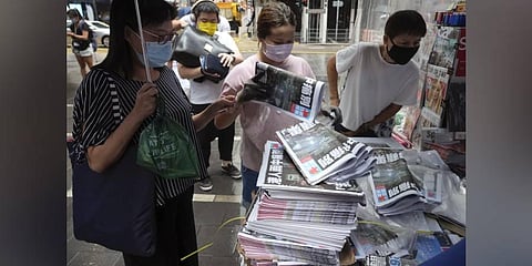 People queue up to buy last issue of Apple Daily at a newspaper booth at a downtown street in Hong Kong. (Photo | AP)