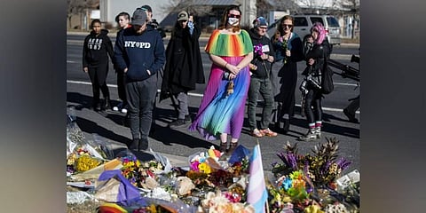 Amanda Kirkbird, center, stands in front of a memorial outside of Club Q following Saturday's fatal shooting at the gay club on Monday. (Photo | AP)