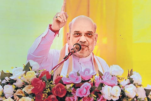 Amit Shah addresses a rally at Kodinar in Gir Somnath district on Monday. (Photo | PTI)