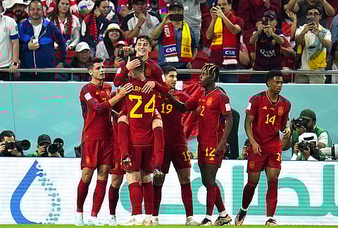 Spain's Gavi, top, jumps over teammate Aymeric Laporte after scoring his side's firth goal during the World Cup group E match against Costa Rica, Nov. 23, 2022. (Photo | AP)