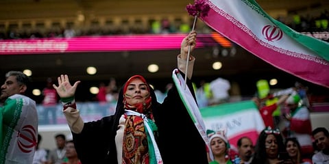 A soccer fan holds a flag from Iran prior to the World Cup group B soccer match between Wales and Iran, at the Ahmad Bin Ali Stadium in Al Rayyan. (Photo | AP)
