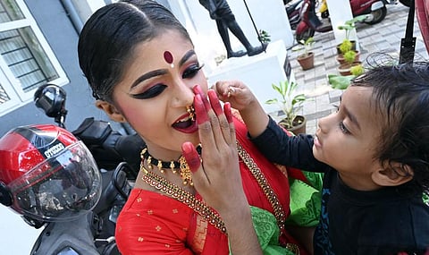 A toddler tries to snatch nose ring from his sister who has put on makeup ahead of the Kuchipudi competition in the Thiruvananthapuram Revenue District Arts Festival on Thursday | Vincent Pulickal
