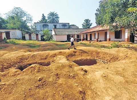 A student walks past the huge pits dug on the premises of Maidalpur nodal upper primary school | Express