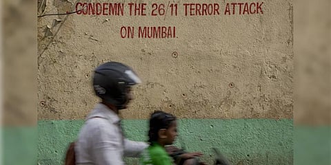 Pedestrians walk past bullet holes marked outside Nariman House, one of the sites of the 2008 Mumbai terror attacks in Mumbai. (Photo | PTI)