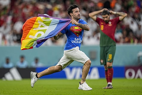 A pitch invader runs across the field with a rainbow flag during the World Cup group H soccer match between Portugal and Uruguay (Photo | AP)