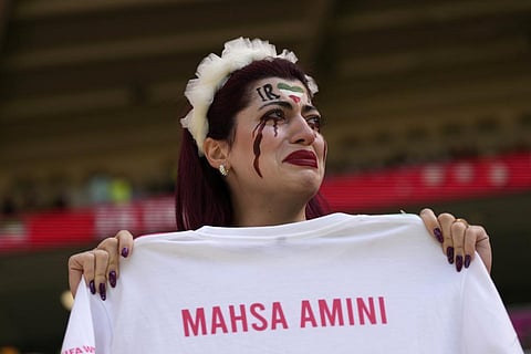 An Iran team supporter cries as she holds a shirt that reads 'Mahsa Amini' prior to the start of the World Cup group B soccer match between Wales and Iran, Nov. 25, 2022. (Photo | AP)