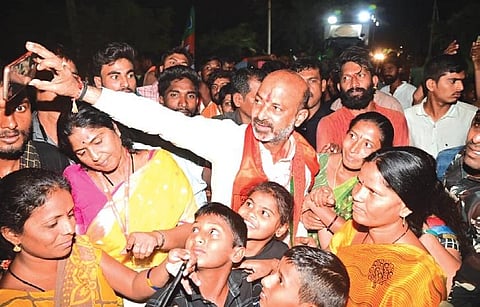 BJP State president Bandi Sanjay takes a selfie with supporters after launching the fifth phase of his ‘Praja Sangrama Yatra’ from Bhainsa in Nirmal district on Tuesday. (Photo | EPS)