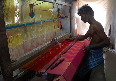 Representational image of a weaver at work in weaving golden threads into the red silk saree. (Photo | Ashwin Prasath, EPS)