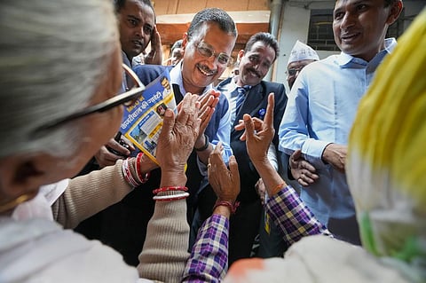 Delhi Chief Minister and AAP Convener Arvind Kejriwal greets supporters during a door-to-door election campaign for the upcoming MCD elections, at Chirag Delhi. (Photo | PTI)