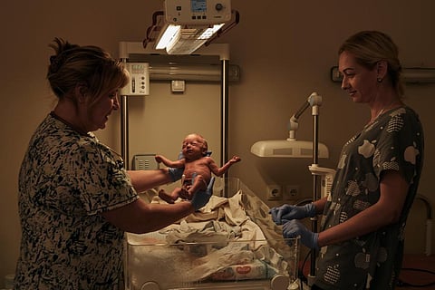 A medic holds a newborn baby in a city hospital in Mykolaiv, the site of heavy battles with Russian forces, Ukraine, Thursday, Nov. 3, 2022. (Photo | AP)