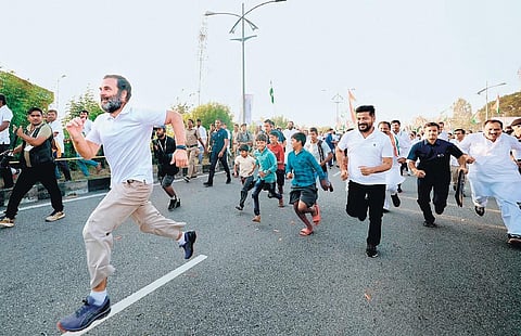 In Telangana, TPCC chief Revanth Reddy tries to catch up with Rahul Gandhi as they race during the Bharat Jodo Yarta at Rajapur, Jadcherla.
