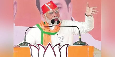 Prime Minister Narendra Modi waves at supporters during a public meeting at Kaprada in Valsad district on Sunday. (Photo | PTI)