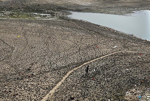 A man walks across a dried patch of the river Yamuna as the water level reduces drastically following a heat wave in New Delhi, May 2, 2022. (File Photo | AP)