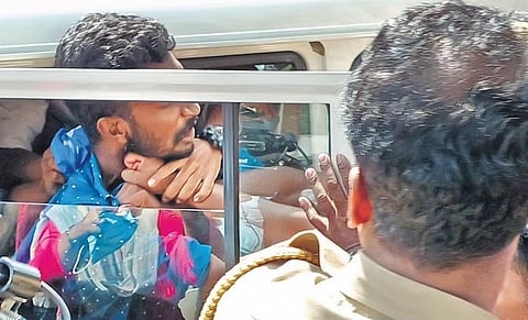 A KSU activist struggles for breath as he is taken into a jeep by policemen