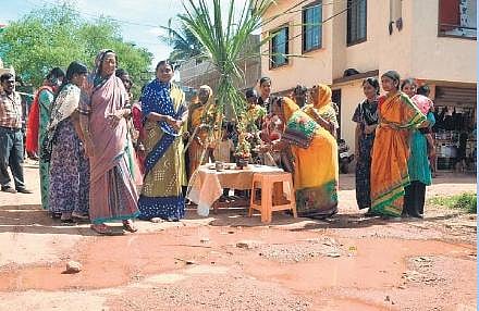 Women of Gopanakoppa in Hubballi perform tulasi puja on a road under repair as a mark of protest   | D Hemanth