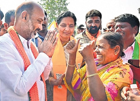 BJP State president Bandi Sanjay interacts with a supporter on the third day of the fifth phase of his Praja Sangrama Yatra in Mudhole of Nirmal district on Wednesday. (Photo | EPS)