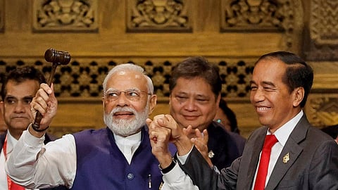 India's Prime Minister Narendra Modi, holds the gavel beside Indonesia's President Joko Widodo, (R) during the handover ceremony at the G20 Leaders' Summit, in Bali, Nov. 16, 2022. (Photo | AP)