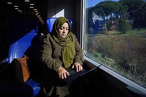 Batool Haidari, 37 works at her laptop on a train taking her from her home on the outskirts of Rome, to the capital's center (Photo | AP)