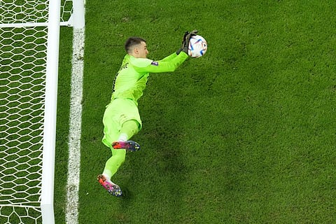 Dominik Livakovic saves a shot during a penalty shootout during the World Cup quarterfinal soccer match against Brazil, at the Education City Stadium, Qatar, Dec. 9, 2022. (Photo  | AP)