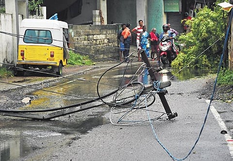 Uprooted by squally winds, an electric post lies on ground with cables at Pandian Road near Neelangarai on Saturday | Ashwin Prasath