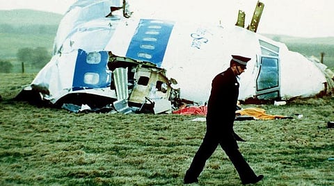 A police officer walks on Dec. 21, 1988, by the nose of Pan Am Flight 103 near Lockerbie, Scotland, where it lay after a bomb aboard exploded, killing a total of 270 people. (Photo AP)
